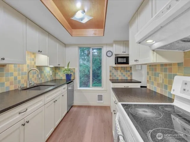 a kitchen with granite countertop a sink stove and cabinets