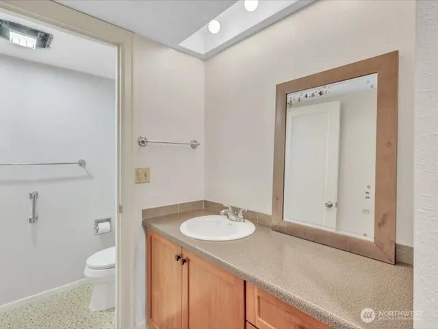a bathroom with a sink a toilet and shower