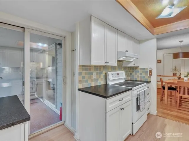 a kitchen with white cabinets and white appliances