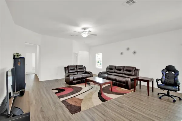 a living room with furniture and wooden floor