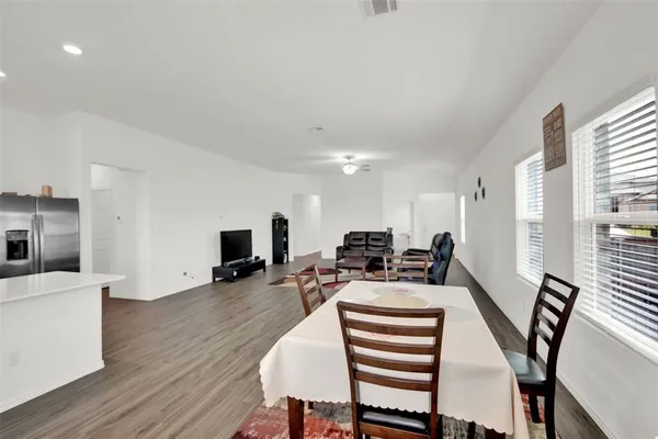 a view of a dining room with furniture a fireplace and wooden floor