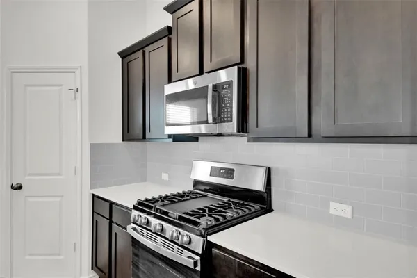 a kitchen with granite countertop a stove and a microwave