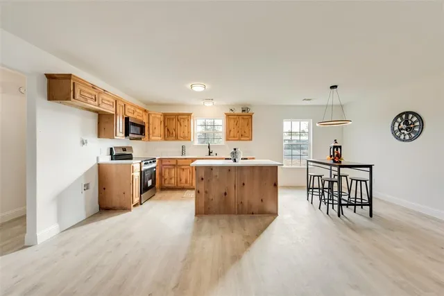 a large white kitchen with a window and stainless steel appliances