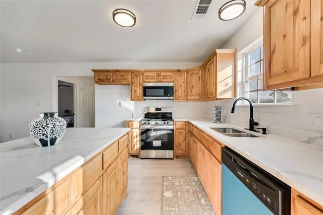 a kitchen with kitchen island a sink stainless steel appliances and cabinets