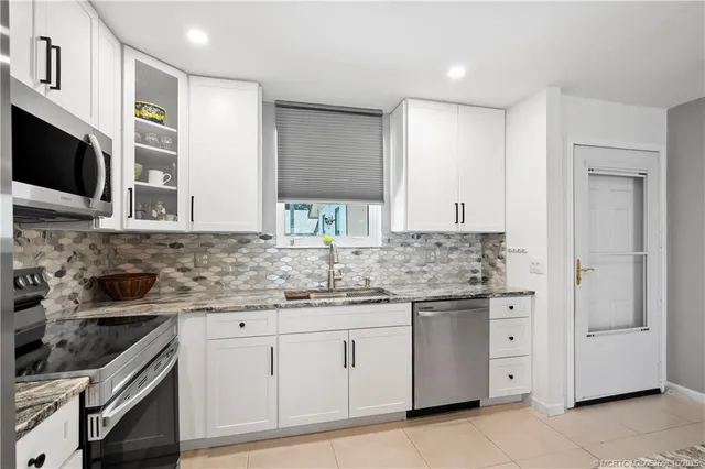 a kitchen with white cabinets and appliances