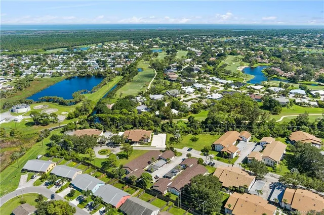an aerial view of residential houses with outdoor space and trees