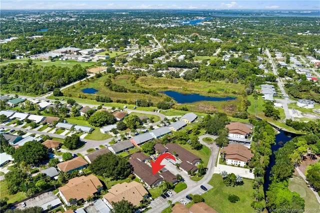 an aerial view of residential houses with outdoor space and trees