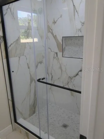 a bathroom with a glass shower door
