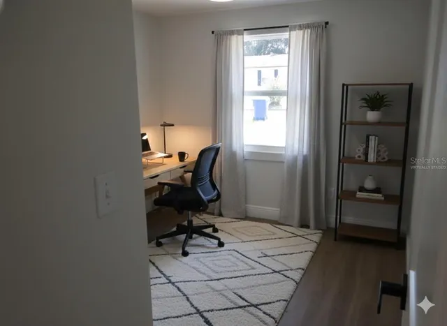 a view of a workspace with furniture and a window