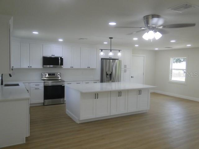 820 Dove Ridge Drive Lakeland, FL 33803 - Photo 5 of 21 a kitchen with kitchen island granite countertop stainless steel appliances cabinets a sink and a counter top space