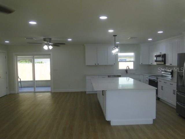 820 Dove Ridge Drive Lakeland, FL 33803 - Photo 7 of 21 a large kitchen with stainless steel appliances a large counter top a stove a chimney a sink and a refrigerator