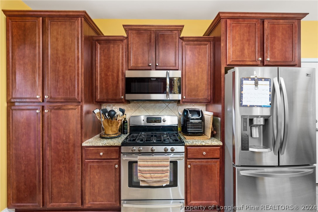 5078 Aberdeen Road Raeford, NC 28376 - Photo 16 of 46 a kitchen with a refrigerator stove and cabinets