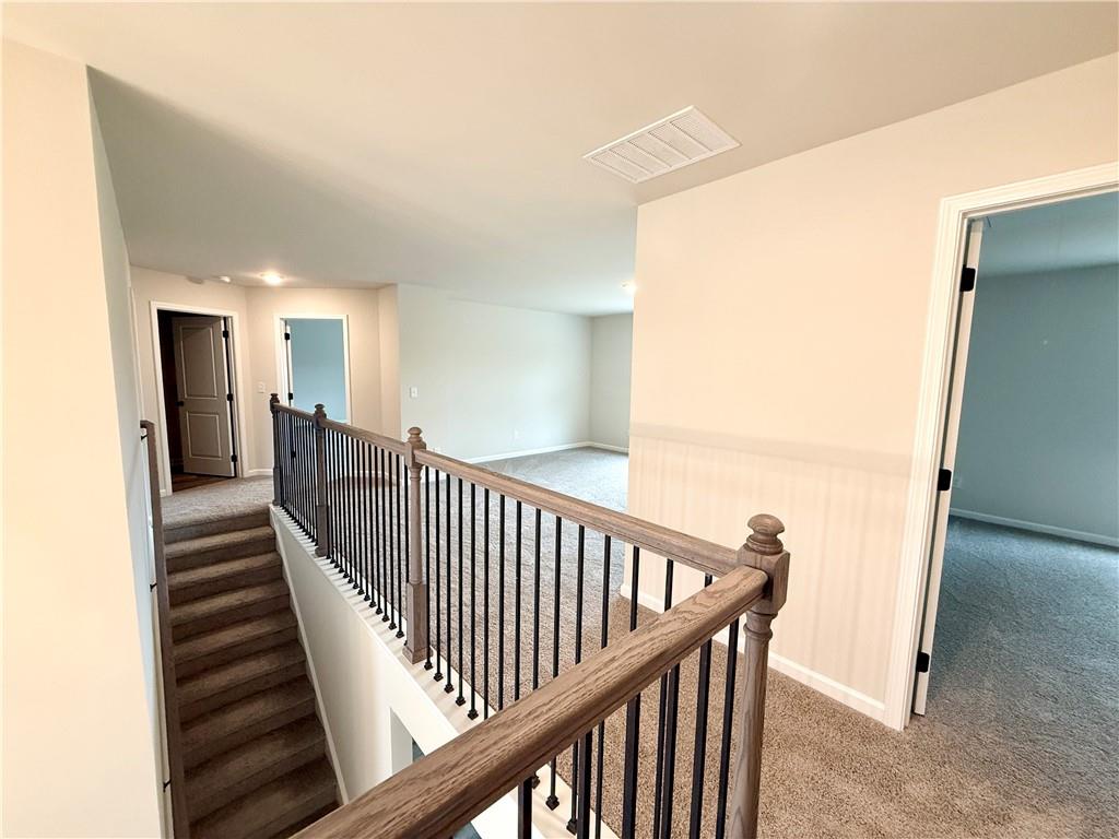 2506 Sunny Hill Road Buford, GA 30519 - Photo 18 of 25 a view of a hallway with wooden floor and staircase