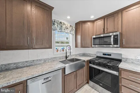 a kitchen with stainless steel appliances granite countertop a sink stove and microwave