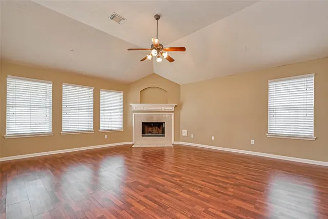 a view of a livingroom with a fireplace wooden floor and windows