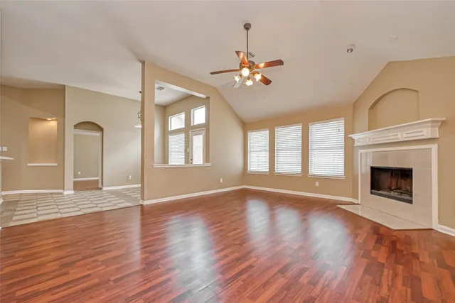 a view of an empty room with a fireplace and wooden floor
