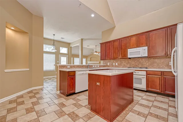 a kitchen with stainless steel appliances granite countertop a stove a sink and a microwave