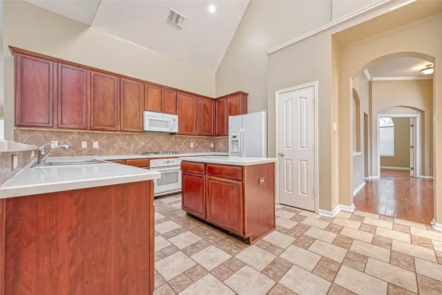 a kitchen with stainless steel appliances granite countertop a stove a sink and a refrigerator