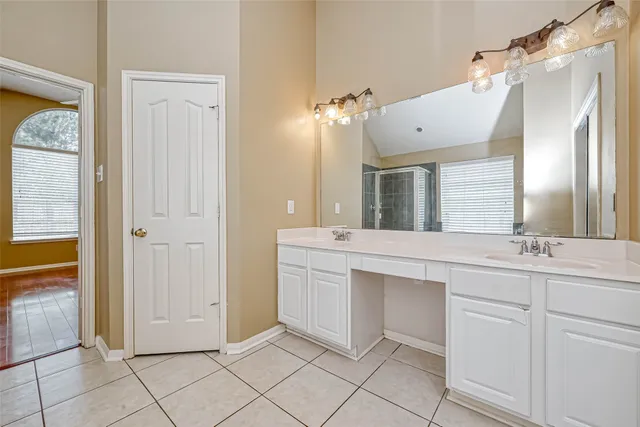 a spacious bathroom with a double vanity sink and a mirror