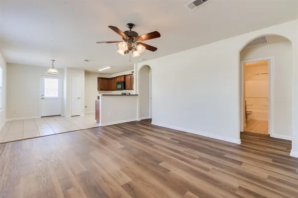 a view of an empty room with window and wooden floor