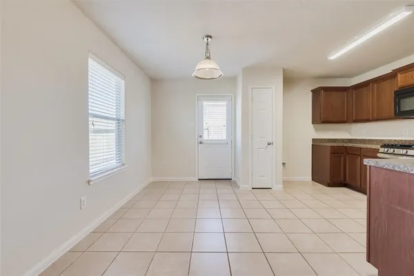 a view of an empty room with window and cabinet