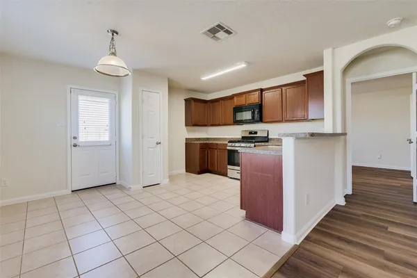 a kitchen with stainless steel appliances granite countertop a refrigerator and a stove top oven
