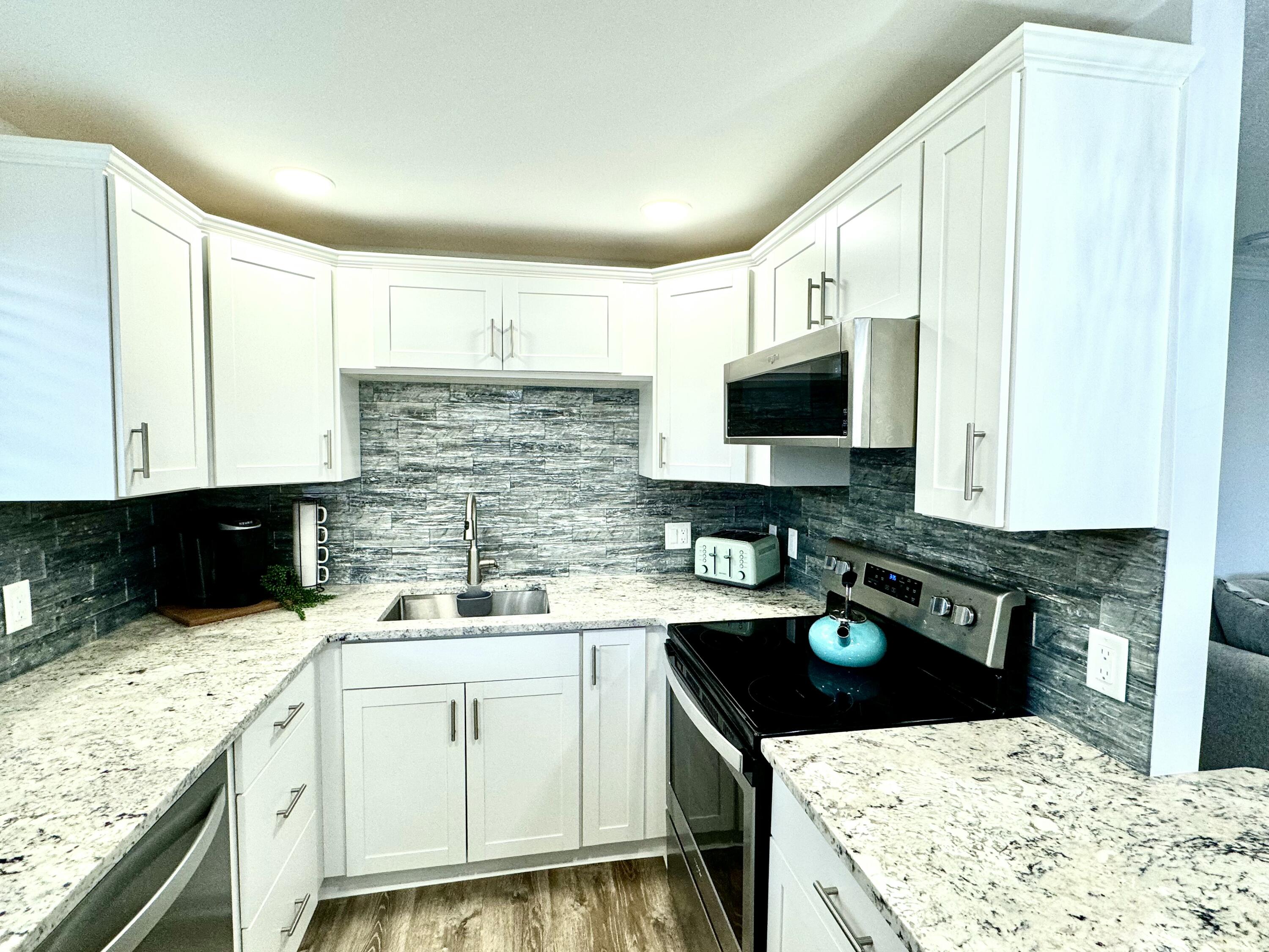 177 Brittany Terrace Delray Beach, FL 33446 - Photo 1 of 24 a kitchen with a stove a sink and a microwave