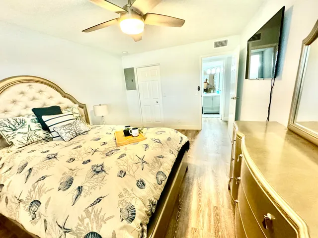 a view of a bedroom with a bed and wooden floor