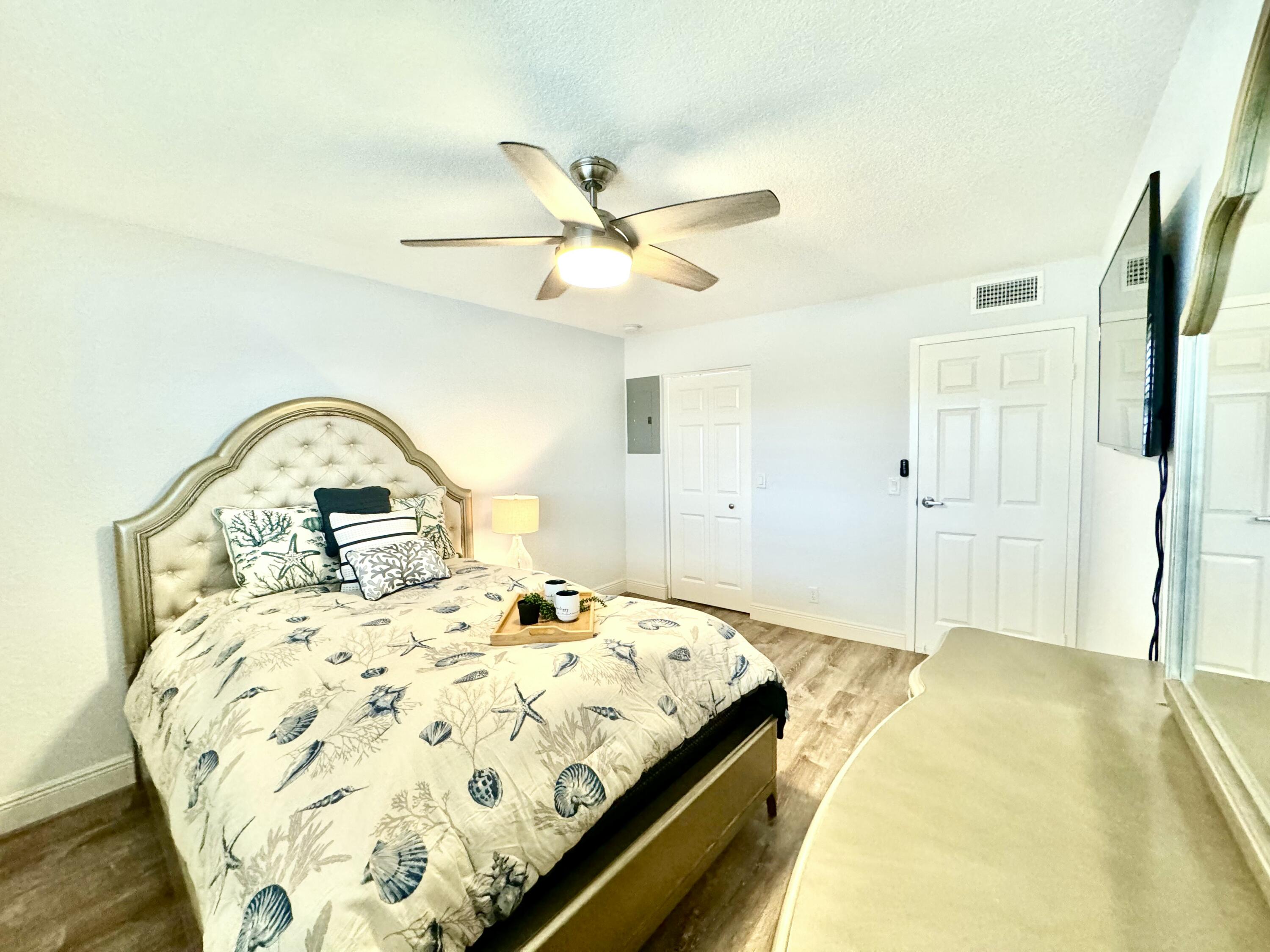 177 Brittany Terrace Delray Beach, FL 33446 - Photo 12 of 24 a bedroom with a bed and a chandelier