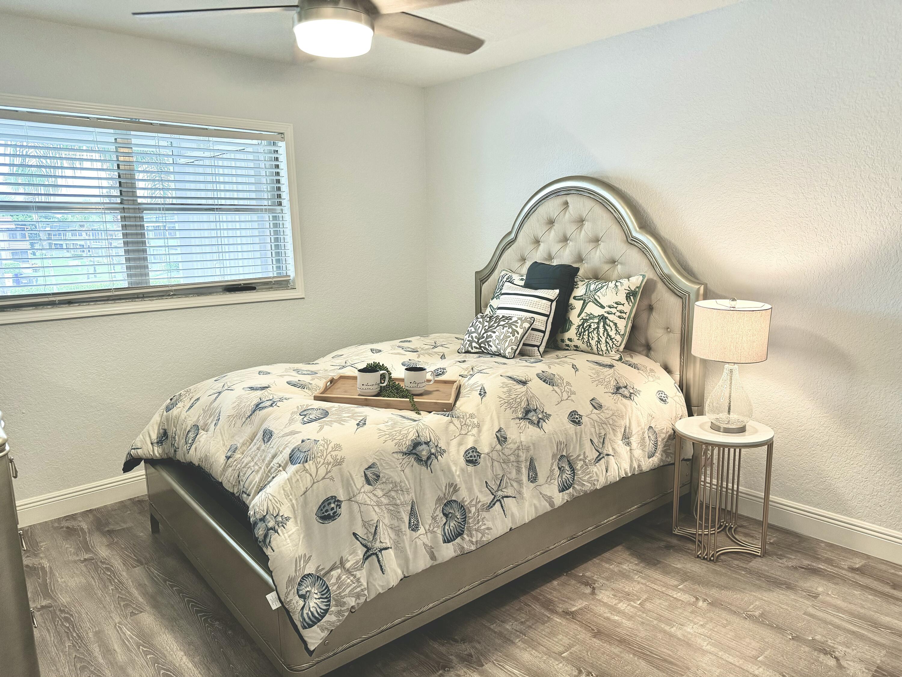 177 Brittany Terrace Delray Beach, FL 33446 - Photo 18 of 24 a bed sitting in a bedroom next to a window