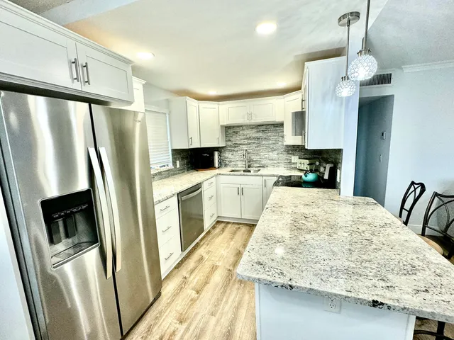 a kitchen with stainless steel appliances a refrigerator sink and stove