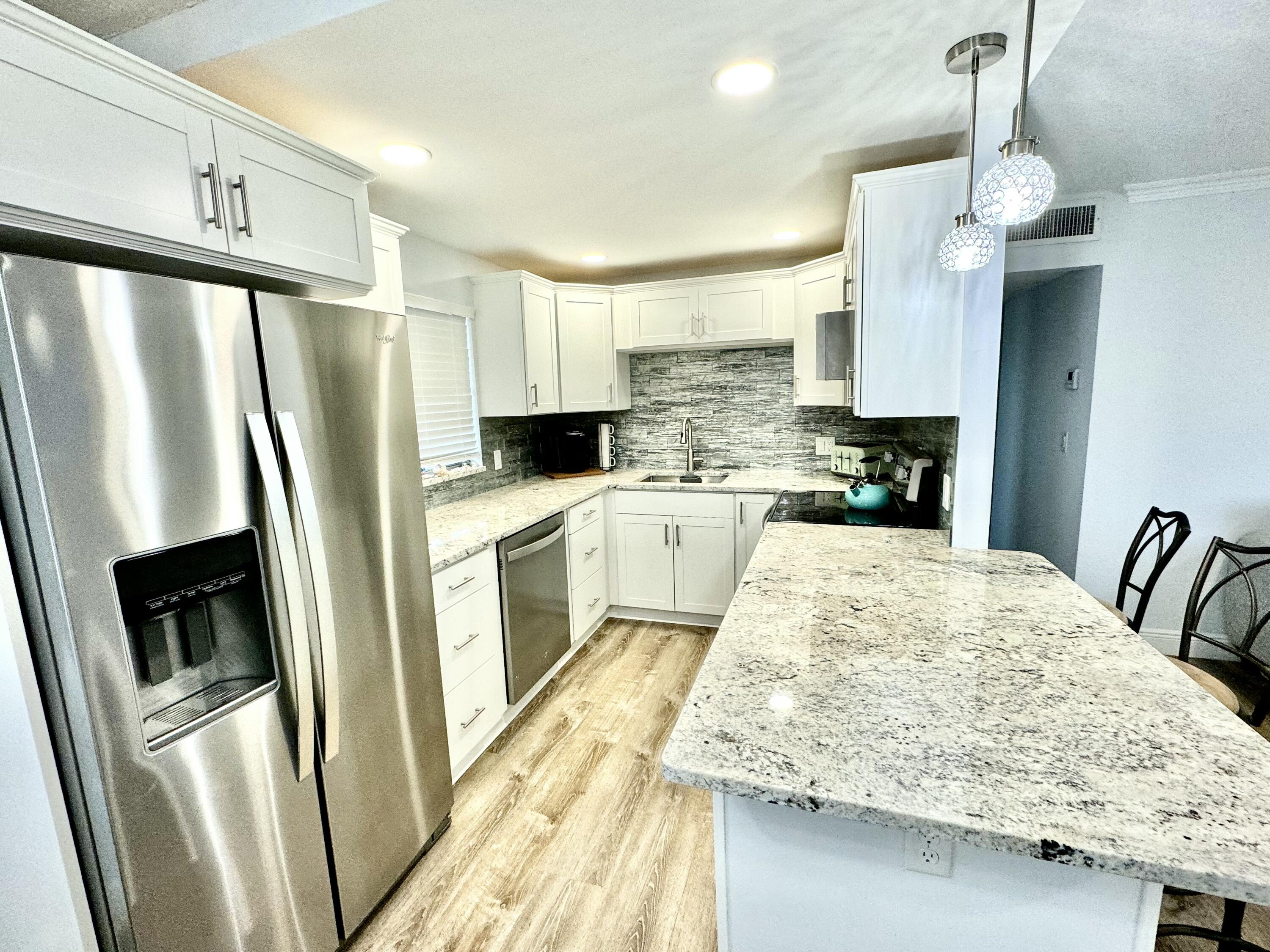 177 Brittany Terrace Delray Beach, FL 33446 - Photo 3 of 24 a kitchen with stainless steel appliances a refrigerator sink and stove