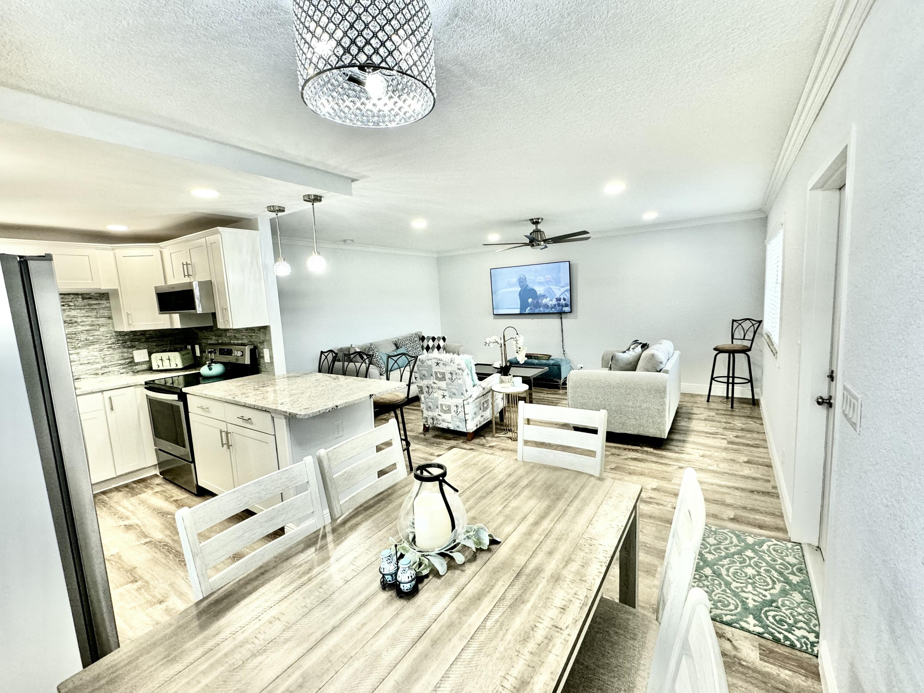 177 Brittany Terrace Delray Beach, FL 33446 - Photo 8 of 24 a living room with furniture a rug and kitchen view