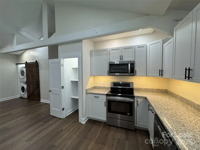 a kitchen with stainless steel appliances granite countertop a stove and a refrigerator
