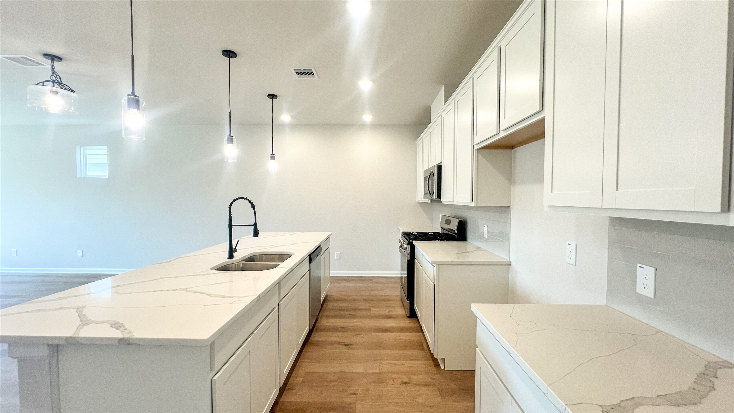 8126 Red Shiner Way Fulshear, TX 77441 - Photo 4 of 20 a large white kitchen with a sink a stove and a refrigerator