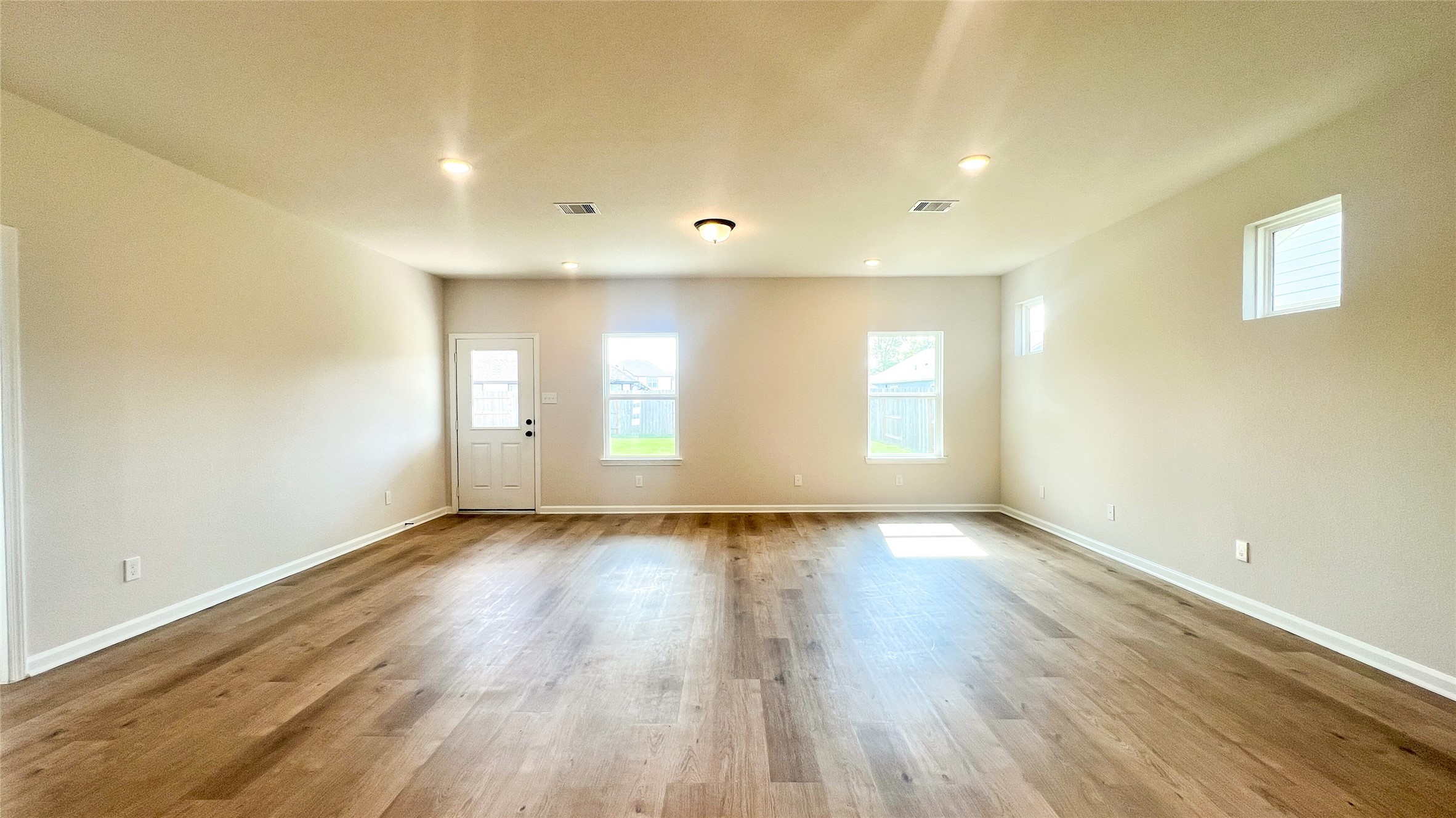 8126 Red Shiner Way Fulshear, TX 77441 - Photo 6 of 20 a view of an empty room with wooden floor and a window