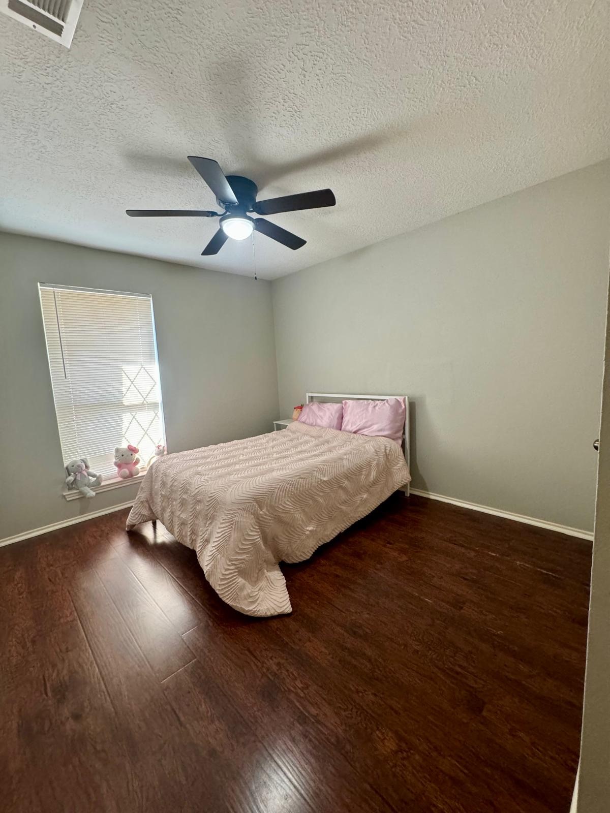 21418 Bassbrook Drive Spring, TX 77388 - Photo 12 of 29 a bedroom with a bed and wooden floor