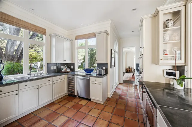 a spacious bathroom with a sink a toilet a mirror and a large window