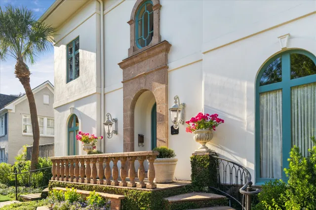 a view of a house with a balcony and flower garden