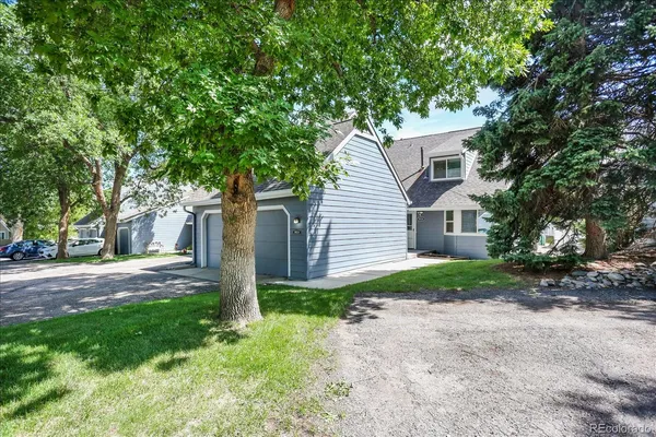 a view of a yard in front of a house with large tree