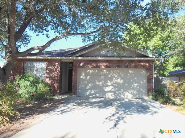 a front view of a house with a tree