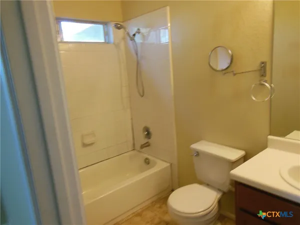 a white toilet sitting next to a bath tub