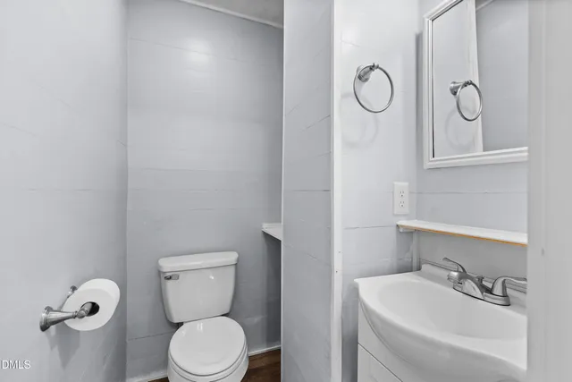 a bathroom with a toilet sink vanity and mirror