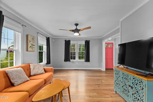 a living room with furniture tv and a window