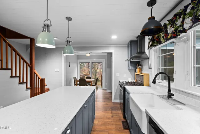 a dining room with stainless steel appliances kitchen island a chandelier a dining table and chairs