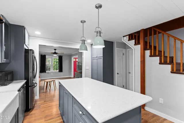 a kitchen with stainless steel appliances kitchen island a refrigerator sink and cabinets