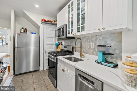 a kitchen with a refrigerator and a stove top oven