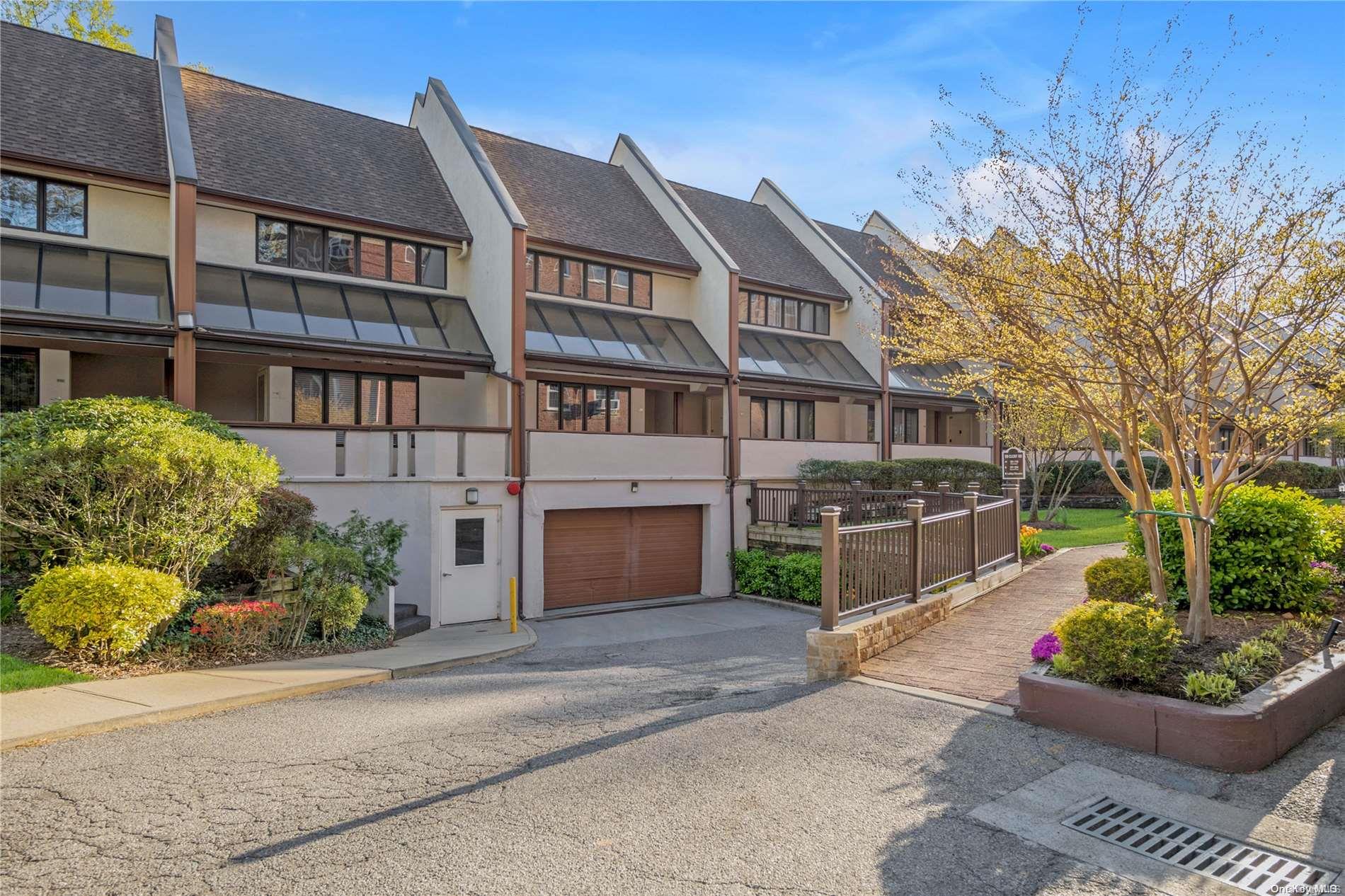 99 Clent Road, Unit E203 Great Neck, NY 11021 - Photo 1 of 1 a front view of a building with garden