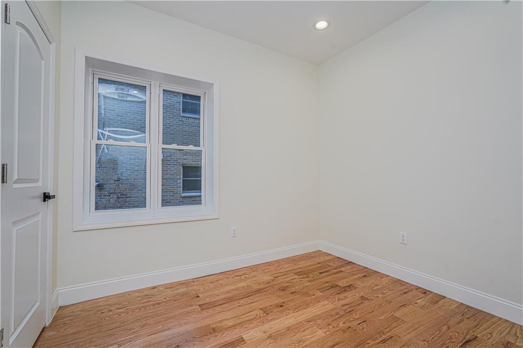 160 Bay 29th Street Brooklyn, NY 11214 - Photo 15 of 27 an empty room with wooden floor and windows