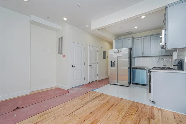 a view of a kitchen with refrigerator and white cabinets